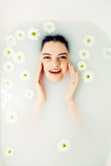 Spa and Beauty. Young beautiful woman bathing with petals. Treatment, body care therapy.