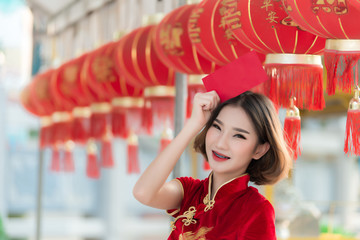 Portrait beautiful asian woman in Cheongsam dress,Thailand people,Happy Chinese new year concept,Happy  asian lady in chinese traditional dress holding a red envelope