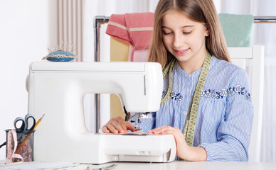 Teenager girl working with sewing machine as a tailor