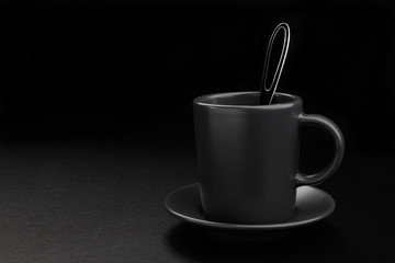 Coffee cup with spoon on black background