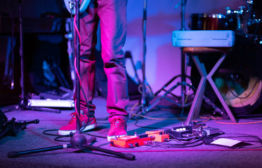 Professional musician using pedals and amplifier at concert