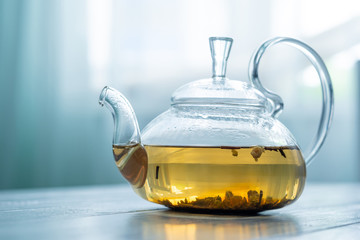 Tasty green tea in traditional kettle on wooden table