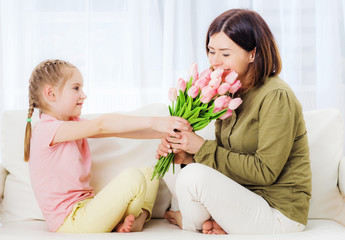 Fototapeta na wymiar Loving kid giving bouquet of flowers to congratulate on Mothers day
