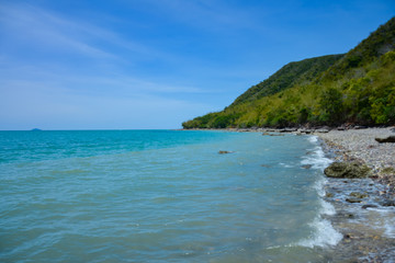 Naklejka premium Beautiful rock beach with sea ocean and mountain blue sky landscape background,An island in the sea with beaches, rocks and turquoise water in the hot summer sun of Thailand.