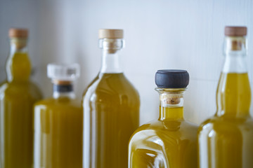 still life, bright and sunny detail of bottles blurred in shel house with reflections liquid olive oil, organic fresh raw warm closeup