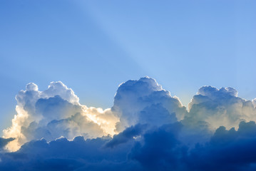 Large clouds on a background of blue sky. Sunlight in the clouds. Cumulus clouds