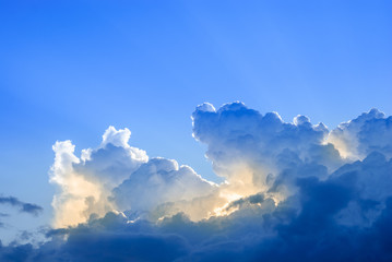 Large clouds on a background of blue sky. Sunlight in the clouds. Cumulus clouds