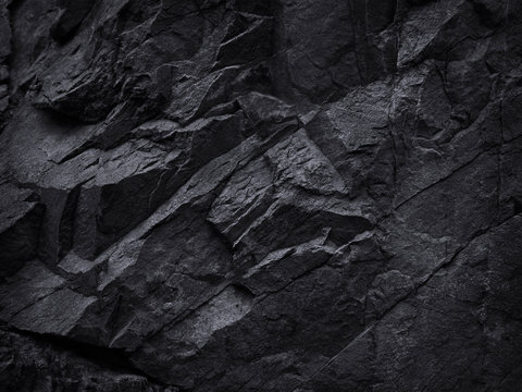 Mountain background texture. Close-up. Black rock background. Dark gray stone background. Black and white background. Black grunge texture. Contrast monochrome rocky texture.