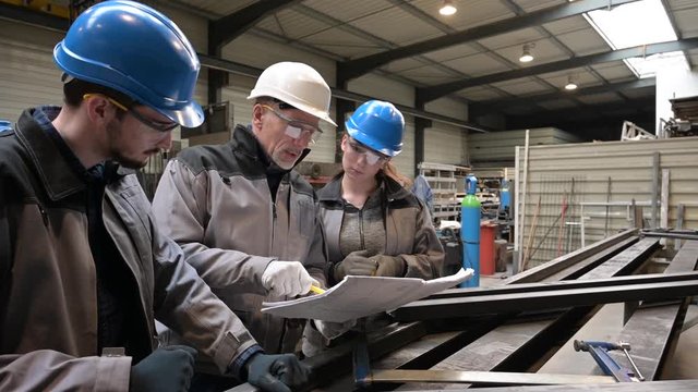 Steelwork instructor with young apprentice in workshop
