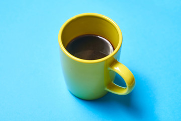 green cup with coffee on a blue background.