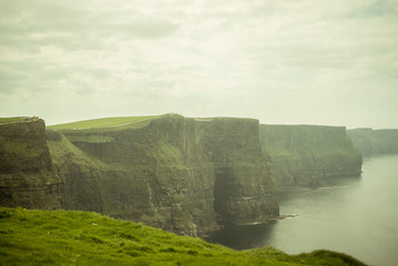 Spectacular views of the famous cliffs of Moher in County Clare, Ireland. A cloudy and foggy day.