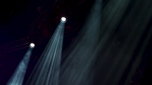 Smoke and visible light beams with a black backgorund on a professional concert stage.