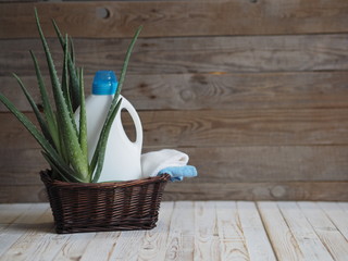 The concept of eco-friendly natural detergents. Detergents and cleaners with aloe vera plant on a wooden background in a natural basket from a vine for linen. Village.