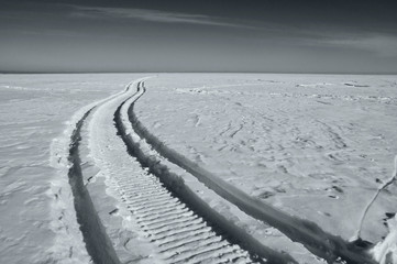 Footprints in the snow, frost, sunny weather, black and white photo.