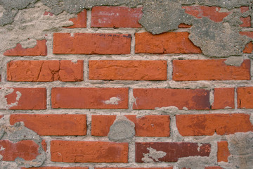 Old brick wall with the remains of plaster