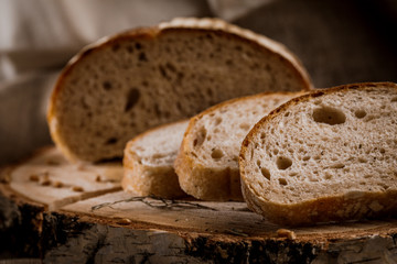 Freshly baked bread cut into chunks on a wooden Board