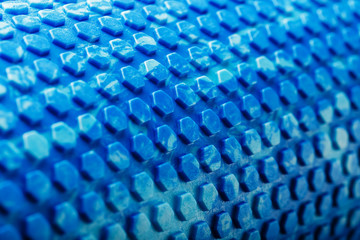 Abstract texture of a blue massage roller in the form of blue hexagonal cells. The entire screen as...