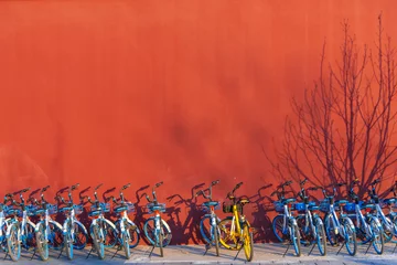 Printed kitchen splashbacks Red 2 Beijing, China-31 December 2019, Row of share bikes parking on footpath with red wall in Beijijng city, China.