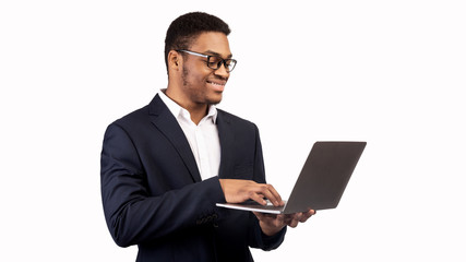 Smiling african american guy holding personal computer