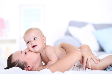 Young mother with baby boy lying on bed