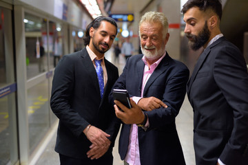 Three multi ethnic bearded businessmen together around the city - Powered by Adobe