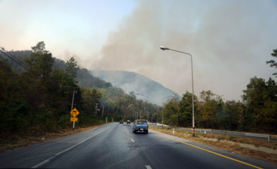 Blurred images of  Smoke caused by forest fires on the side of the highway. Air pollution haze in Thailand caused by forest fire.