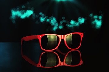 Sensual sunglasses.Color lights on background.
