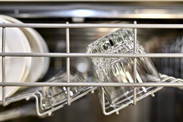 Pure utensils sparkle and shine on the top shelf of the dishwasher, front view.