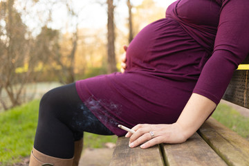 Close-up on pregnant woman with cigarette