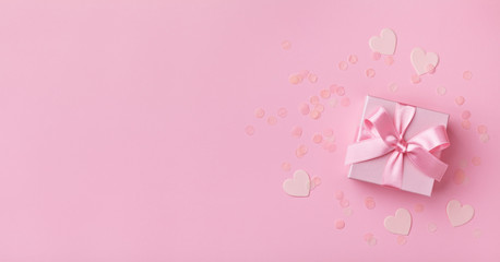 Gift box and confetti hearts. Pink pastel color. Flat lay style. Valentines day concept.