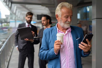 Three multi ethnic bearded businessmen together around the city