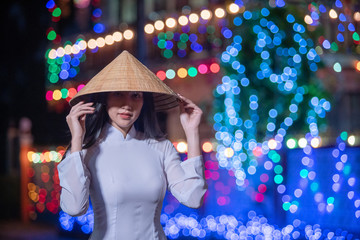 Beautiful woman wearing Ao Dai Vietnamese traditional dress and tourist in the old house France...