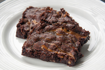 Brownies with caramel on white plate
