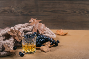 A glass of whiskey or bourbon, spices and decoration on dark background