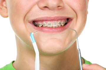 Young man with toothbrush and dentist tool on white background