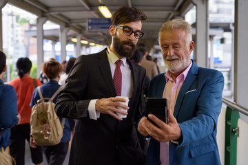 Two multi ethnic bearded businessmen together around the city