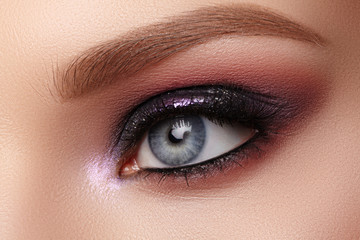 Beautiful Closeup Eye Make-up with Purple Glitter Shadows. Fashion Celebrate Makeup, Clean Skin, perfect Shapes of Brows