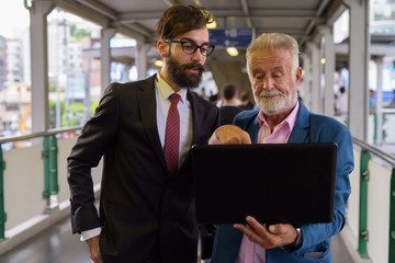 Two multi ethnic bearded businessmen together around the city