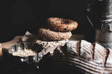 Variety of bagels on dark background; bakery concept.