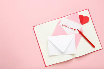 Paper envelopes with red heart, notepad and text With Love on pink background