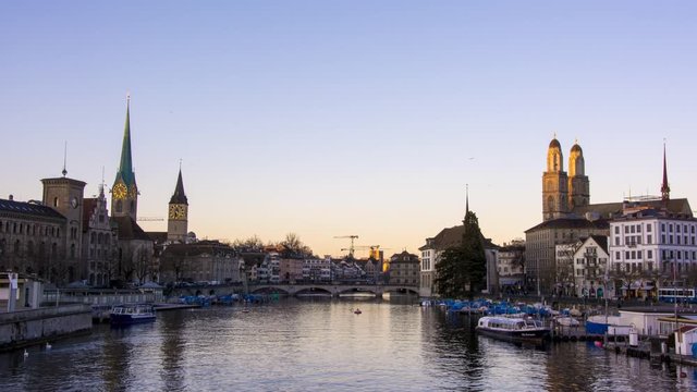 timelapse sunset over zurich city bellevue switzerland with river limmat. downtown zurich orange sunset over grossm&uuml;nster and frauenkirche