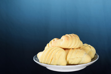 plate with typical Brazilian snack baked cheese cracker isolated on blue gradient background with space for text