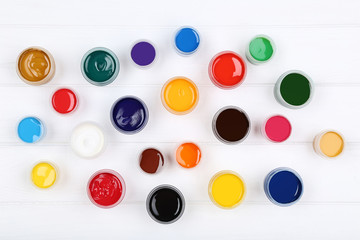 Colorful gouache paints on white wooden table