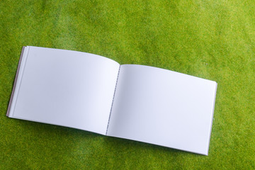 white otebook on green background