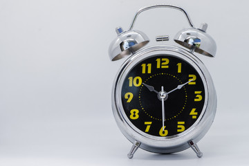 The alarm clock on the table in the white room