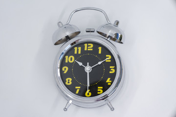 The alarm clock on the table in the white room
