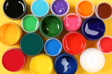 Colorful gouache paints on yellow background
