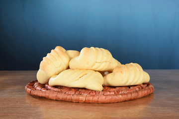 plate with typical Brazilian snack baked cheese cracker isolated on blue gradient background with space for text
