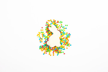Easter bunny shape and multi-colored decoration on a light background. Easter concept, New Year. Minimalism. Flat lay, top view