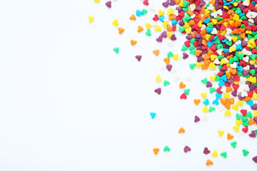 Colorful heart shaped sprinkles on white background